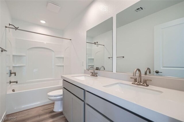 9842 Lost Horse Ave, Las Vegas, NV 89178 - bathroom featuring toilet, double vanity, tub / shower combination, and wood finished floors