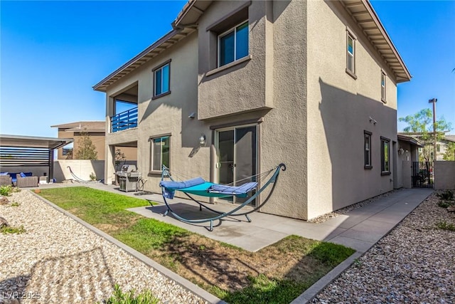 12332 Switchgrass Ave, Las Vegas, NV 89138 - rear view of house featuring stucco siding, a balcony, a patio area, and a gate