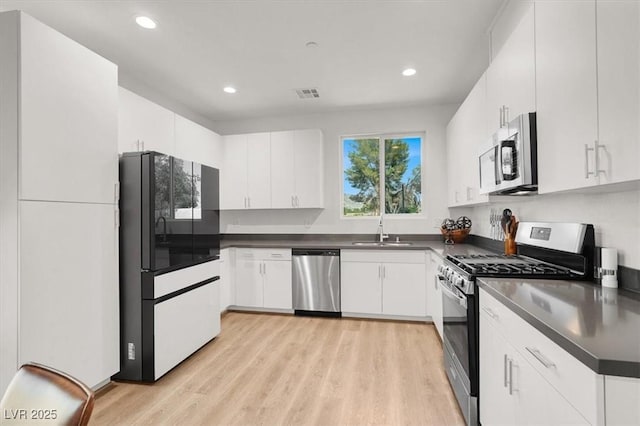 66 Chelsea Manor Ct, Las Vegas, NV 89110 - kitchen featuring appliances with stainless steel finishes, a sink, dark countertops, light wood-style floors, and recessed lighting