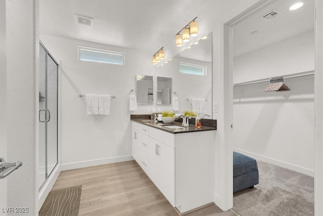 66 Chelsea Manor Ct, Las Vegas, NV 89110 - full bathroom with double vanity, a walk in closet, a stall shower, and plenty of natural light
