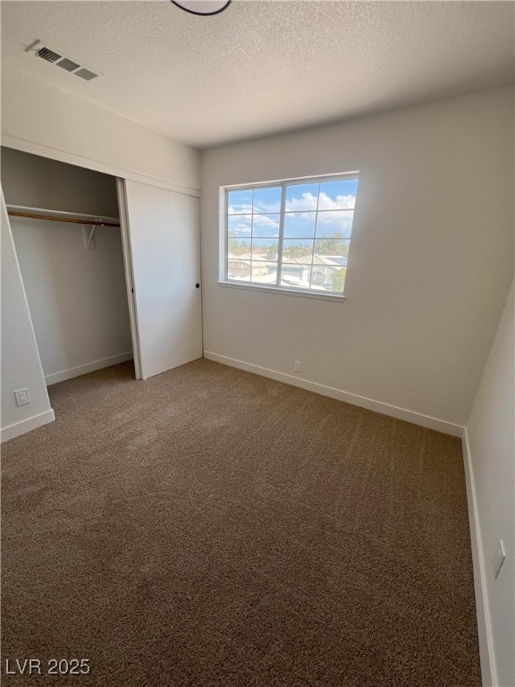 8068 Cetus Cir, Las Vegas, NV 89128 - unfurnished bedroom with carpet flooring, a closet, a textured ceiling, and baseboards