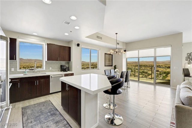 8255 Las Vegas Blvd Unit 1821, Las Vegas, NV 89123 - kitchen featuring stainless steel dishwasher, a sink, open floor plan, light countertops, and a breakfast bar area