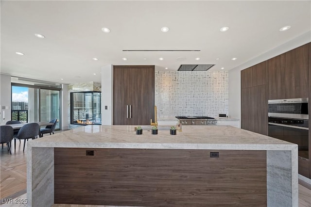 1 Hughes Center Dr Unit 1901, Las Vegas, NV 89169 - kitchen with modern cabinets, wall oven, light countertops, decorative backsplash, and a large island