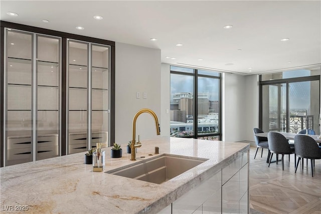 1 Hughes Center Dr Unit 1901, Las Vegas, NV 89169 - kitchen featuring a sink, light stone counters, a wall of windows, and recessed lighting