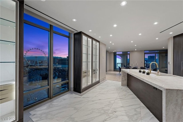 1 Hughes Center Dr Unit 1901, Las Vegas, NV 89169 - kitchen with light marble finish flooring, recessed lighting, a center island with sink, light stone countertops, and a sink
