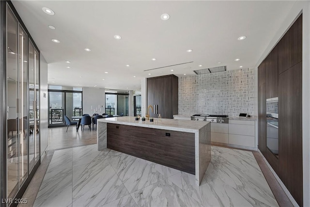 1 Hughes Center Dr Unit 1901, Las Vegas, NV 89169 - kitchen with modern cabinets, a spacious island, backsplash, recessed lighting, and dark brown cabinets