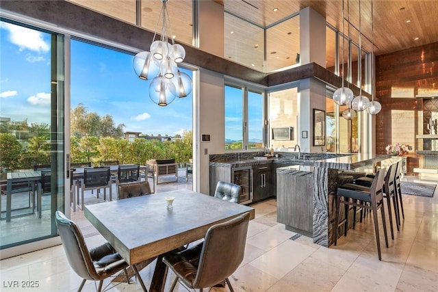 8 Meadowhawk Ln, Las Vegas, NV 89135 - dining area with a chandelier, a high ceiling, wooden walls, wooden ceiling, and light tile patterned floors