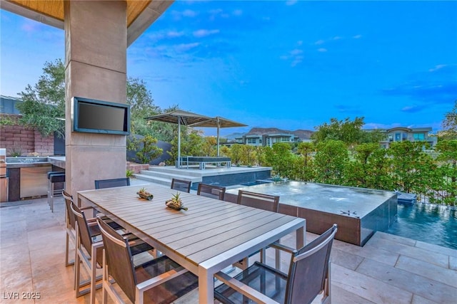 8 Meadowhawk Ln, Las Vegas, NV 89135 - view of patio with outdoor dining area, an outdoor hot tub, an infinity pool, and a large fireplace