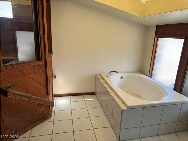 1674 Seneca Ln, Las Vegas, NV 89169 - bathroom with plenty of natural light, baseboards, a bath, tile patterned floors, and a textured wall