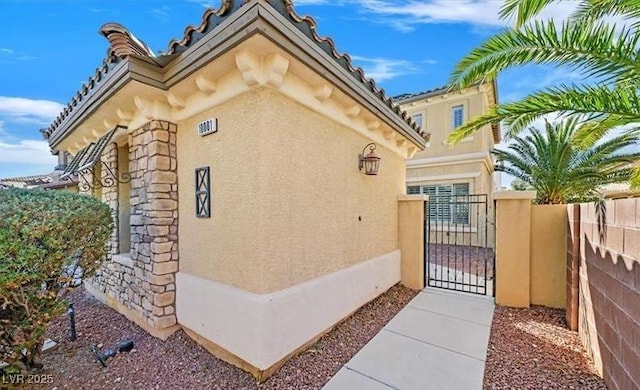 10001 Blairwood Ct, Las Vegas, NV 89178 - view of home's exterior with stucco siding, a gate, and a tiled roof