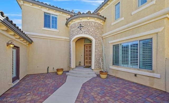 10001 Blairwood Ct, Las Vegas, NV 89178 - property entrance with stucco siding, stone siding, and a patio area
