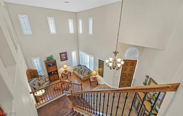 10001 Blairwood Ct, Las Vegas, NV 89178 - stairs with a towering ceiling, a chandelier, and wood finished floors