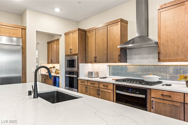 230 Cactus Sunrise St, Las Vegas, NV 89138 - kitchen with appliances with stainless steel finishes, wall chimney exhaust hood, a sink, light stone countertops, and tasteful backsplash