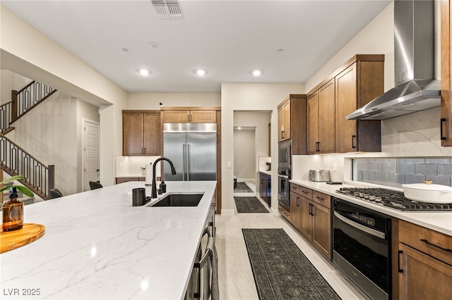 230 Cactus Sunrise St, Las Vegas, NV 89138 - kitchen with built in appliances, wall chimney range hood, a sink, tasteful backsplash, and light stone countertops