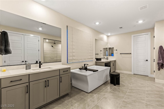 230 Cactus Sunrise St, Las Vegas, NV 89138 - bathroom featuring two vanities, a soaking tub, a tile shower, recessed lighting, and baseboards