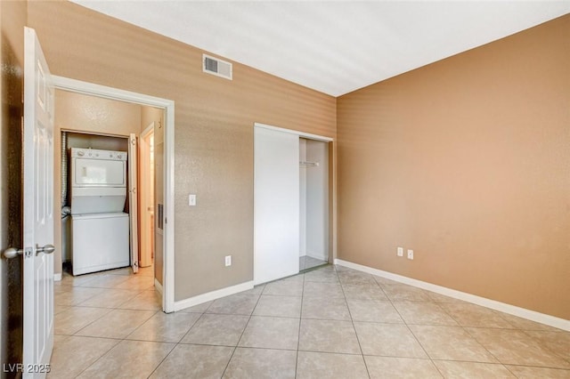 4730 E Craig Rd Unit 1005, Las Vegas, NV 89115 - unfurnished bedroom with estacked washer and dryer, light tile patterned flooring, and a closet