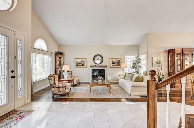 2036 Deer Springs Dr, Henderson, NV 89074 - living area with baseboards, stairs, vaulted ceiling, light tile patterned floors, and a glass covered fireplace