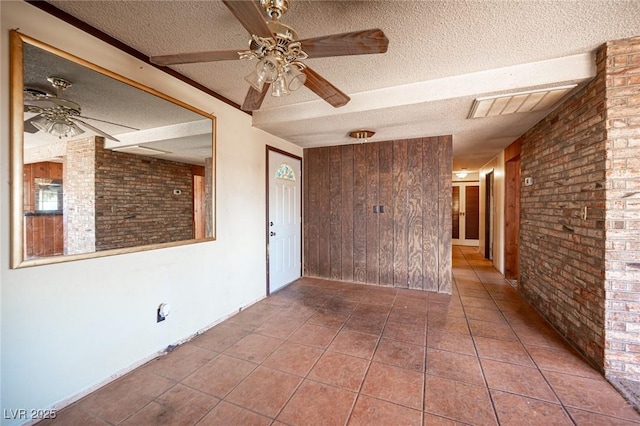4516 E Flamingo Rd, Las Vegas, NV 89121 - empty room featuring a textured ceiling, brick wall, ceiling fan, and tile patterned floors