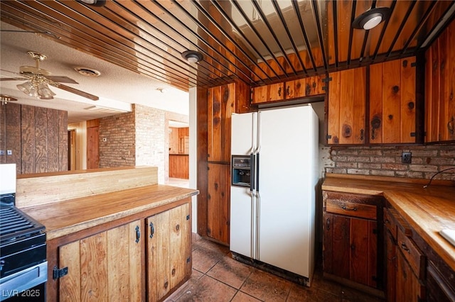 4516 E Flamingo Rd, Las Vegas, NV 89121 - kitchen with white fridge with ice dispenser, butcher block countertops, ceiling fan, and dark tile patterned flooring