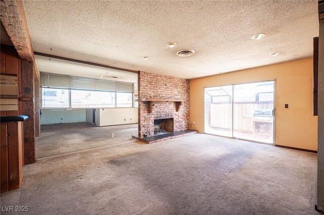 4516 E Flamingo Rd, Las Vegas, NV 89121 - unfurnished living room with a textured ceiling, healthy amount of natural light, carpet floors, and a fireplace