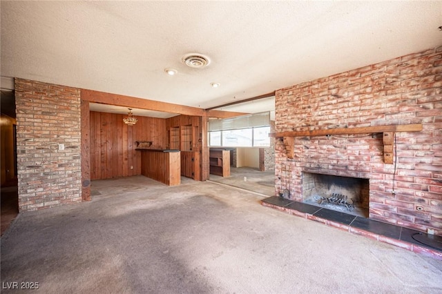 4516 E Flamingo Rd, Las Vegas, NV 89121 - unfurnished living room with light colored carpet, a fireplace, wooden walls, and a textured ceiling