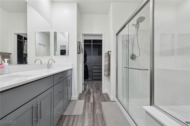 3024 River Brook Ct, Las Vegas, NV 89139 - bathroom with wood finished floors, a shower stall, double vanity, and a walk in closet