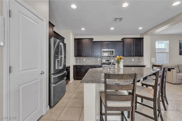 9950 Coyote Echo Ct, Las Vegas, NV 89166 - kitchen featuring appliances with stainless steel finishes, stone countertops, light tile patterned flooring, backsplash, and recessed lighting