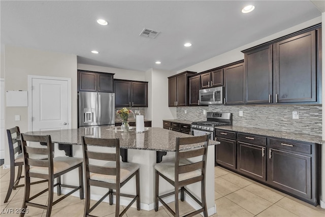 9950 Coyote Echo Ct, Las Vegas, NV 89166 - kitchen with appliances with stainless steel finishes, tasteful backsplash, stone countertops, dark brown cabinets, and recessed lighting