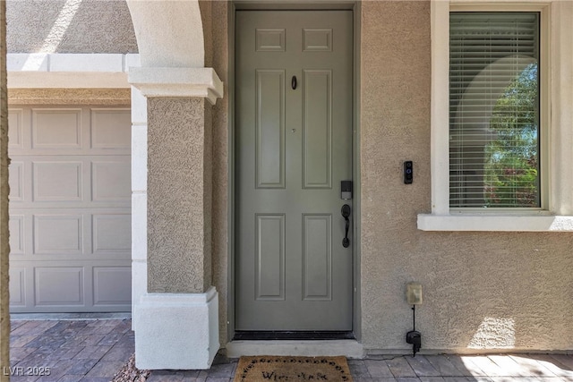 9950 Coyote Echo Ct, Las Vegas, NV 89166 - doorway to property with stucco siding and a garage