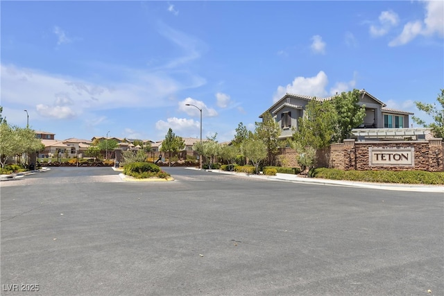 9950 Coyote Echo Ct, Las Vegas, NV 89166 - view of asphalt street with a residential view, street lights, curbs, and a gated entry