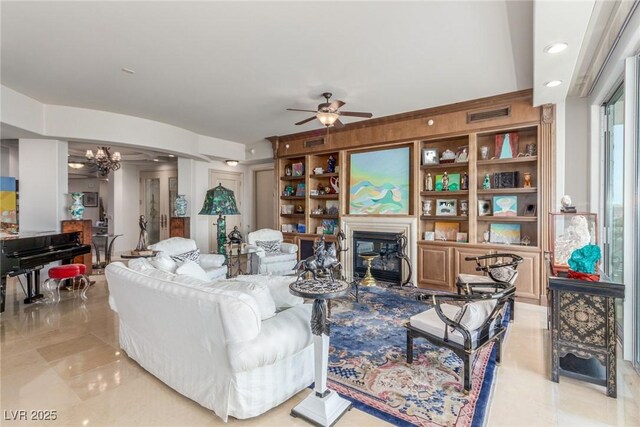 9101 Alta Dr Unit 203, Las Vegas, NV 89145 - tiled living room featuring a chandelier, a ceiling fan, and a glass covered fireplace