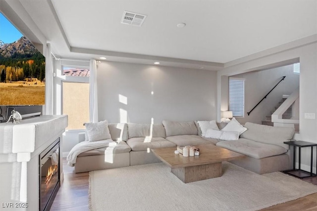 6056 Atlantis Dream Ave, Las Vegas, NV 89139 - living room featuring wood finished floors, recessed lighting, stairway, and a glass covered fireplace
