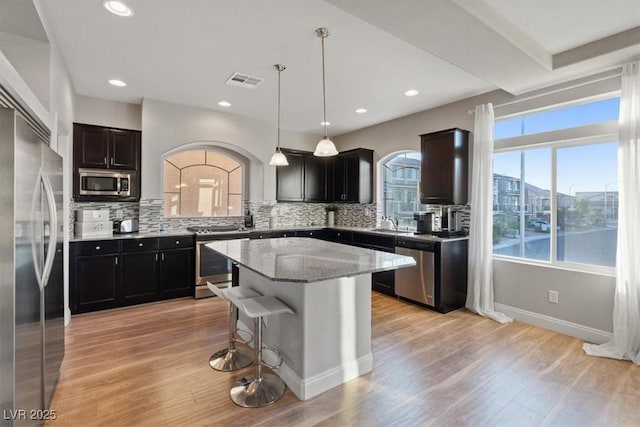 6056 Atlantis Dream Ave, Las Vegas, NV 89139 - kitchen with appliances with stainless steel finishes, tasteful backsplash, light stone countertops, light wood-type flooring, and recessed lighting