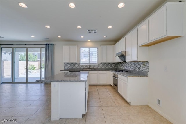 6442 Kobe Knoll Ct, Las Vegas, NV 89141 - kitchen with decorative backsplash, light tile patterned floors, light stone countertops, recessed lighting, and white cabinets