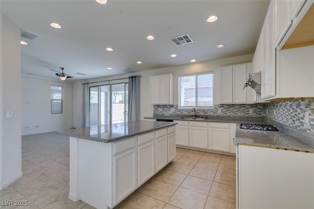 6442 Kobe Knoll Ct, Las Vegas, NV 89141 - kitchen featuring tasteful backsplash, light tile patterned flooring, a kitchen island, dark stone counters, and recessed lighting