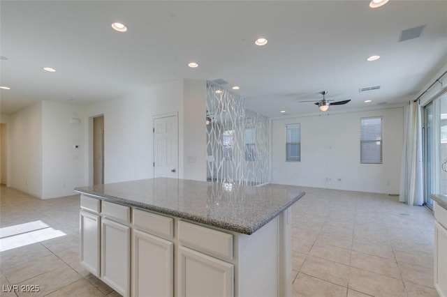 6442 Kobe Knoll Ct, Las Vegas, NV 89141 - kitchen with ceiling fan, recessed lighting, a center island, white cabinetry, and light tile patterned floors