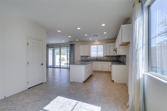 6442 Kobe Knoll Ct, Las Vegas, NV 89141 - kitchen with tasteful backsplash, a center island, recessed lighting, white cabinetry, and dark countertops