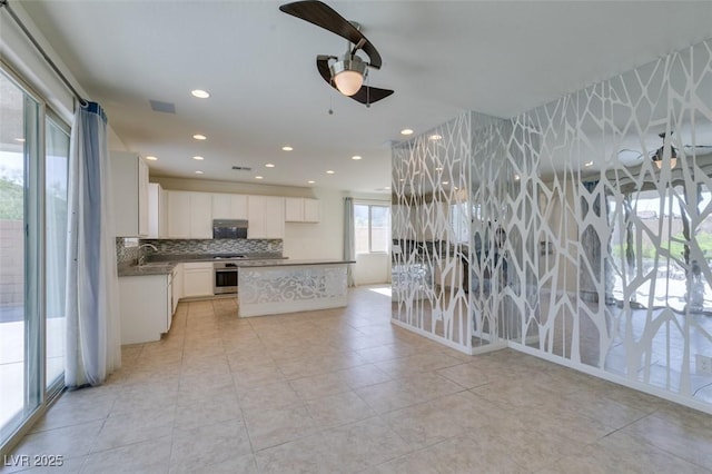 6442 Kobe Knoll Ct, Las Vegas, NV 89141 - kitchen with tasteful backsplash, white cabinets, oven, ceiling fan, and under cabinet range hood