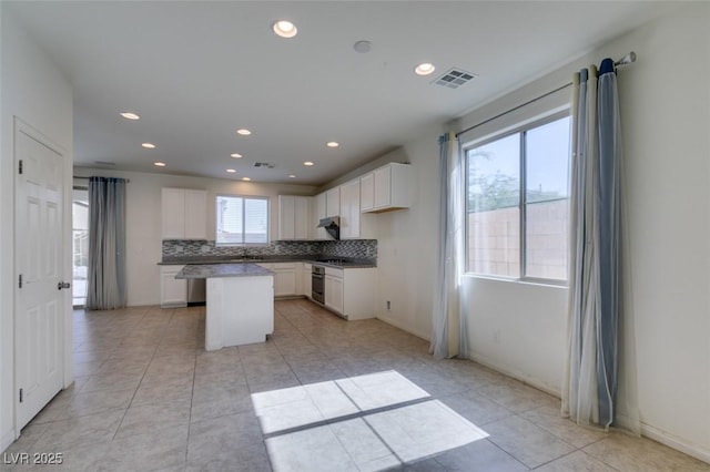 6442 Kobe Knoll Ct, Las Vegas, NV 89141 - kitchen featuring a kitchen island, recessed lighting, light tile patterned floors, tasteful backsplash, and white cabinets