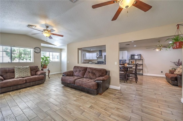 4428 Los Reyes Ct, Las Vegas, NV 89121 - living area featuring a ceiling fan, vaulted ceiling, light wood finished floors, a textured ceiling, and baseboards