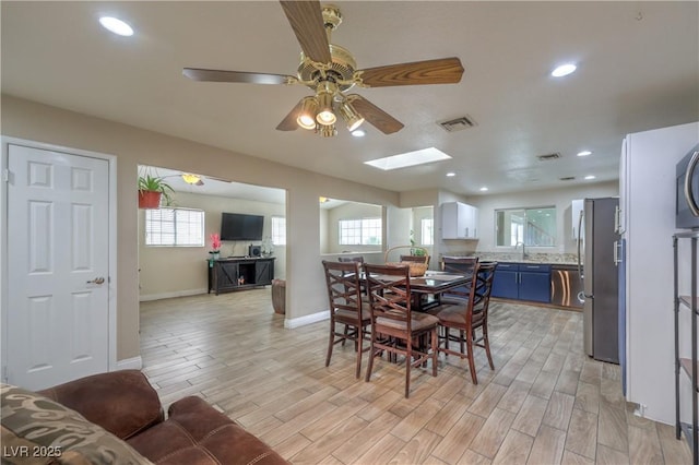 4428 Los Reyes Ct, Las Vegas, NV 89121 - dining area with a ceiling fan, baseboards, light wood-style floors, recessed lighting, and a skylight