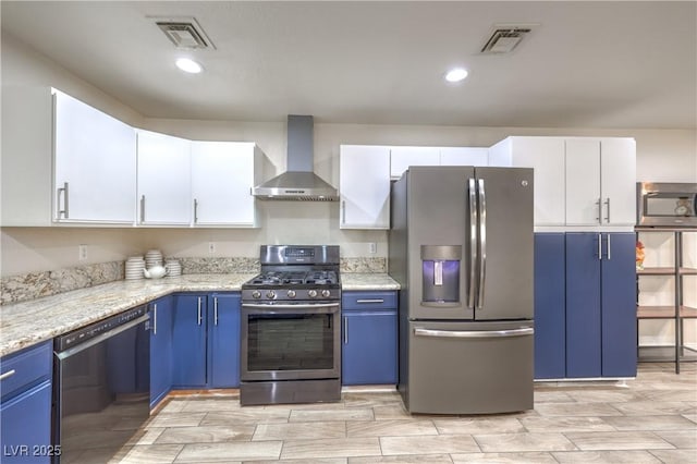 4428 Los Reyes Ct, Las Vegas, NV 89121 - kitchen featuring appliances with stainless steel finishes, wall chimney range hood, blue cabinets, white cabinets, and recessed lighting