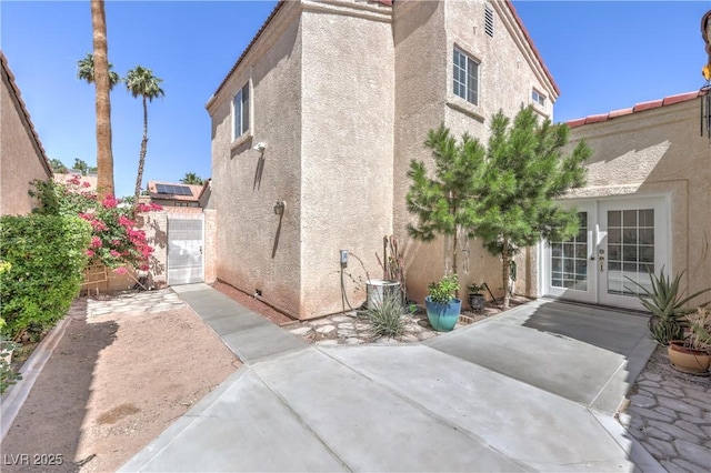 4428 Los Reyes Ct, Las Vegas, NV 89121 - view of side of home with french doors, a patio, and stucco siding