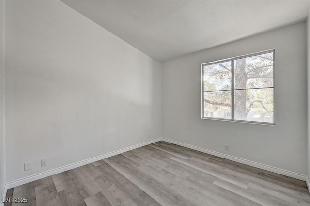 5155 W Tropicana Ave Unit 2095, Las Vegas, NV 89103 - unfurnished room featuring wood finished floors, baseboards, and vaulted ceiling