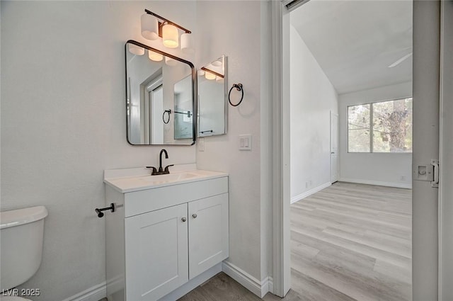 5155 W Tropicana Ave Unit 2095, Las Vegas, NV 89103 - bathroom featuring baseboards, toilet, vanity, and wood finished floors