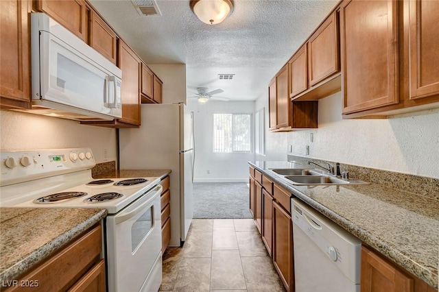 1846 N Decatur Blvd Unit 104, Las Vegas, NV 89108 - kitchen featuring white appliances, light colored carpet, brown cabinets, ceiling fan, and a textured ceiling