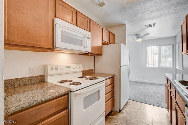 1846 N Decatur Blvd Unit 104, Las Vegas, NV 89108 - kitchen featuring white appliances, ceiling fan, light carpet, brown cabinetry, and a textured ceiling