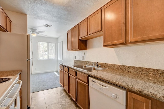 1846 N Decatur Blvd Unit 104, Las Vegas, NV 89108 - kitchen featuring white appliances, light carpet, a ceiling fan, brown cabinets, and a textured ceiling