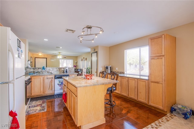 7801 Olympus Ave, Las Vegas, NV 89131 - kitchen featuring freestanding refrigerator, dishwasher, a breakfast bar area, a center island, and backsplash