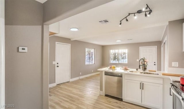 1820 Yale St, North Las Vegas, NV 89030 - kitchen featuring stainless steel appliances, a sink, a peninsula, light wood-type flooring, and white cabinets